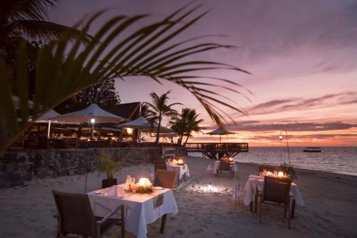a restaurant on the beach with tables and chairs at Castaway Island, Fiji in Castaway Island