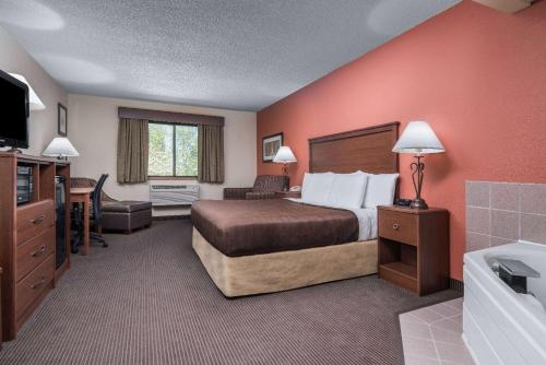 a hotel room with a bed and a bathroom at AmericInn by Wyndham Tofte Near Lake Superior in Tofte