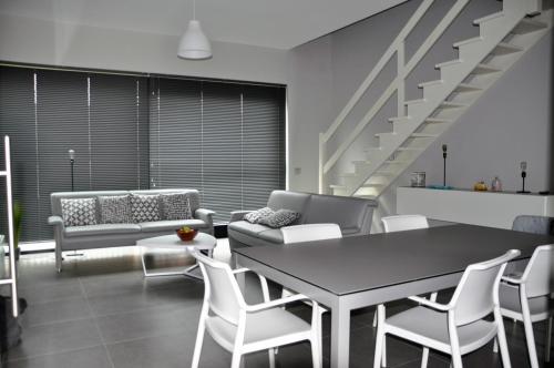 - un salon avec une table et des chaises ainsi qu'un escalier dans l'établissement Holiday Home Rustig Oostende, à Ostende