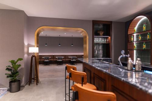 a bar with chairs and a dining room in the background at Radisson Blu Hotel, Amman Galleria Mall in Amman