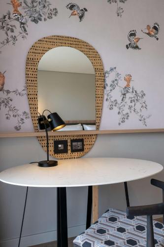 a mirror on a wall with a table and a mirror at Radisson Safari Hotel Hoedspruit in Hoedspruit
