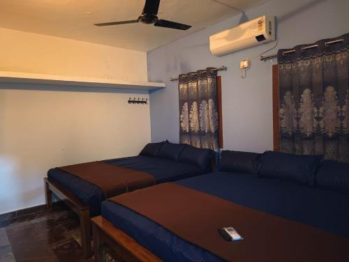 a living room with two beds and a couch at Agnisthala Guest House in Tiruvannāmalai