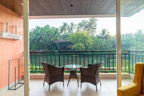 a patio with a table and chairs on a balcony at Mandrem Beach Resort, a member of Radisson Individuals Retreat in Mandrem