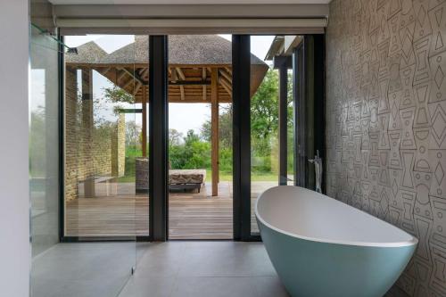 a bathroom with a white bath tub in a room at Radisson Safari Hotel Hoedspruit in Hoedspruit