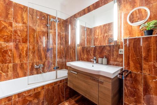 a bathroom with a sink and a shower and a mirror at Nice big apartment 2bds - Belgicka in Prague