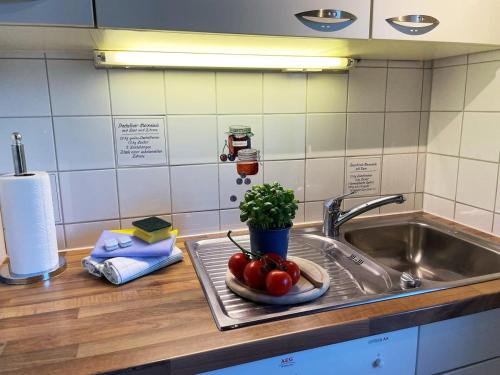 een aanrecht met een wastafel en een bord tomaten bij Haus Benninghusumer Deichweg, eingezäunt, Hunde Willkommen, Kamin, ruhig gelegen, WLAN in Emmelsbüll-Horsbüll