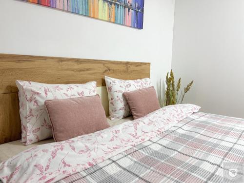 a bedroom with a bed with pink and white pillows at Renthouse Apartments City Gates #2 in Chişinău