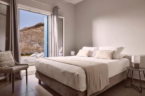 MandrakiaにあるVilla Imperial Milosの白いベッドルーム(大型ベッド1台、窓付)
