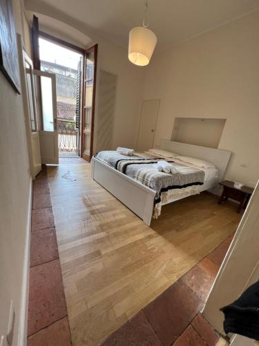 een slaapkamer met een bed en een houten vloer bij Nur 1 Casa Vacanze Bergamo in Bergamo