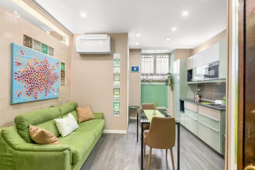a living room with a green couch and a kitchen at GREEN butterfly house holiday in Rome