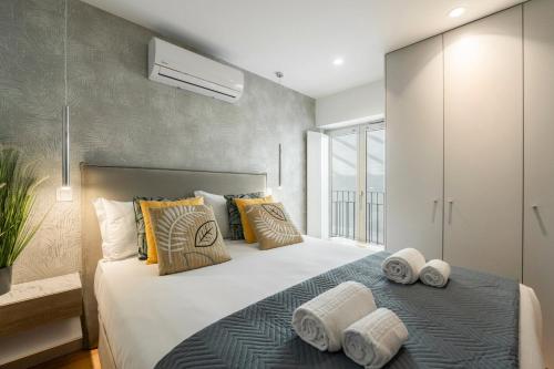 um quarto com uma cama grande e toalhas em GuestReady - Elegant living in Porto city centre no Porto