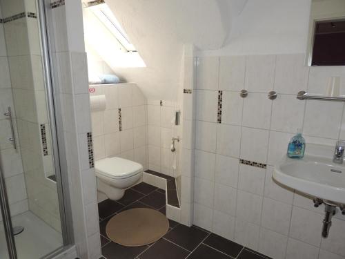 a bathroom with a toilet and a sink at Pension Neuenrade in Neuenrade