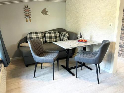 un soggiorno con tavolo, sedie e divano di Hundeurlaub bei Karin, Holzhaus, eingezäunter Garten, E-Ladestation, WLAN, ebenerdig a Emmelsbüll-Horsbüll