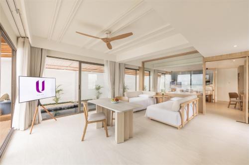 a living room with a white couch and a tv at U Hua Hin in Cha Am