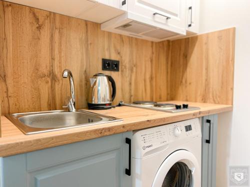 a kitchen with a sink and a washing machine at Renthouse Apartments City Gates #2 in Chişinău