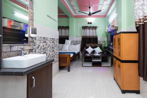 ein Bad mit einem Waschbecken und ein Bett in einem Zimmer in der Unterkunft Raja Hotel & Lodge - Kharagpur, West Bengal in Shyāmalpur