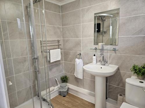 ein Bad mit einer Dusche und einem Waschbecken in der Unterkunft Pet Friendly 2 Bed Coastal Property - Millendreath, Looe in Looe