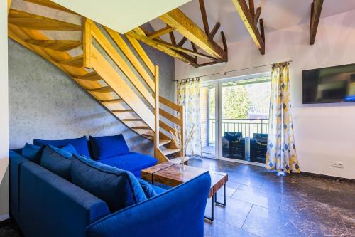 a living room with blue couches and a staircase at Dolina Czyrna - doskonała lokalizacja dla narciarzy - Dream Apart in Szczyrk