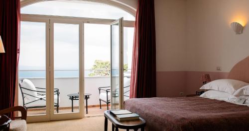 a hotel room with a bed and a balcony at Il Capri Hotel in Capri