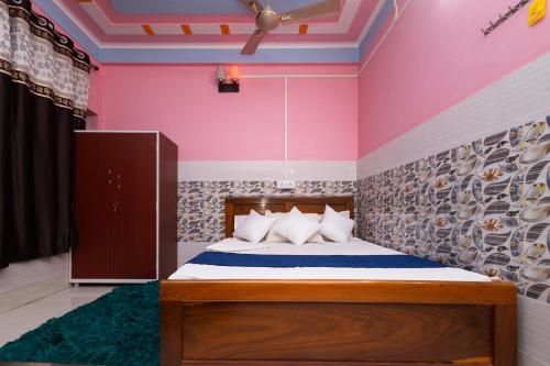 ein Schlafzimmer mit einem Bett und einer rosa Wand in der Unterkunft Raja Hotel & Lodge - Kharagpur, West Bengal in Shyāmalpur