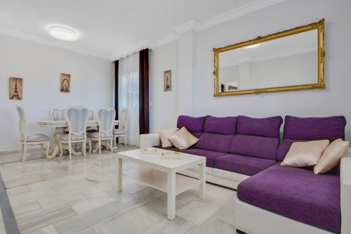 sala de estar con sofá púrpura y mesa en Casa rural Emporio, en Alhaurín de la Torre