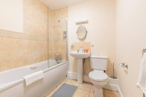 a bathroom with a toilet and a sink and a tub at Comfy - 3 Bedroom Flat With Parking in Southampton