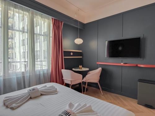 a bedroom with a bed and a tv and a table at Aparthotel AMMI Nice Lafayette in Nice
