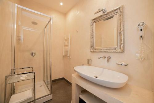 a bathroom with a sink and a shower and a mirror at Al Mirador Resort in Selva di Fasano