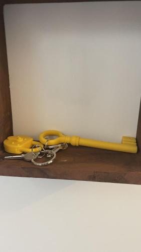 a yellow rope with a pair of keys on a table at Le Clos Du Moulin 2 - Villa jardin 3 chambres près d'Avignon en Provence in Entraigues-sur-la-Sorgue