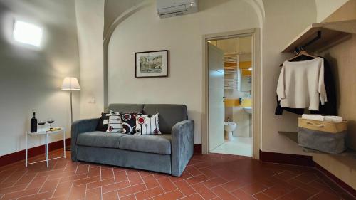 a living room with a couch and a bathroom at Chiostro Delle Monache Hostel Volterra in Volterra