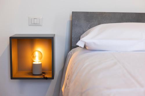 a light bulb in a box next to a bed at Traditional Italian House - Bergamo in Bergamo