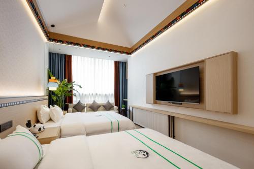 Xishu Garden Inn في تشنغدو: غرفة فندقية بسريرين وتلفزيون بشاشة مسطحة
