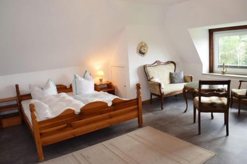 a bedroom with a bed and a chair and a table at Haus Storjohann in Dagebüll