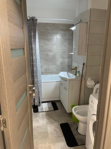 een badkamer met een toilet, een bad en een wastafel bij TwinsHause in Craiova