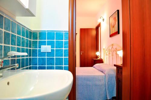 Villa con giardino e piscina privata 45 في مارينا دي بيسكولوس: حمام مع حوض أبيض وبلاط أزرق