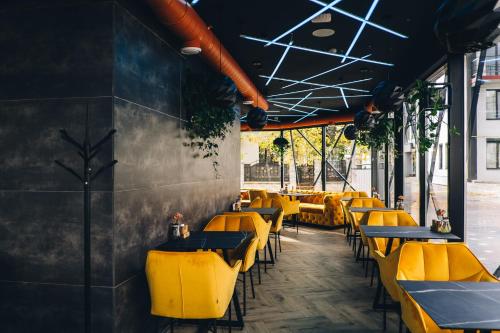 een rij gele tafels en stoelen in een restaurant bij Stella in Ternopilʼ