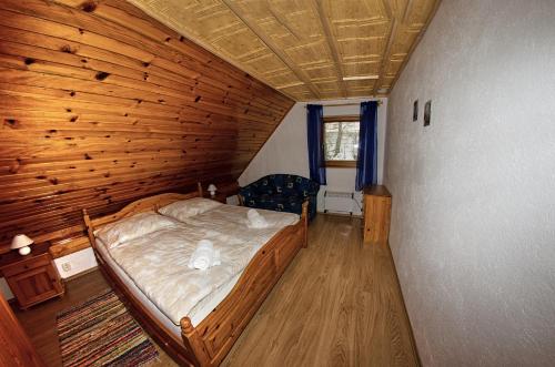 a bedroom with a bed in a wooden room at Apartmany pod Tatrami in Važec