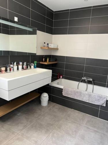 une salle de bain avec un lavabo et une baignoire dans l'établissement Maison avec piscine chauffée, à Aimargues