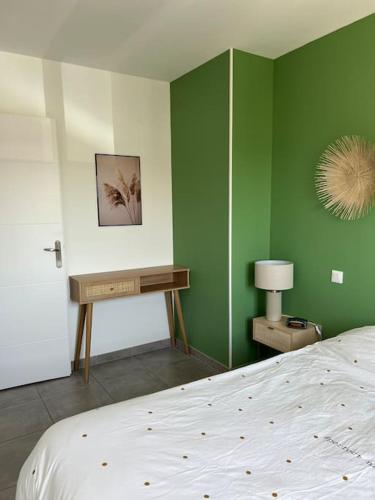 - une chambre avec des murs verts, un lit et un bureau dans l'établissement Maison avec piscine chauffée, à Aimargues