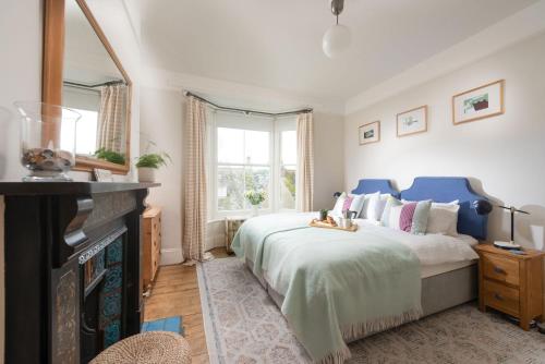 a bedroom with a large bed and a mirror at La Folie, Fowey in Fowey