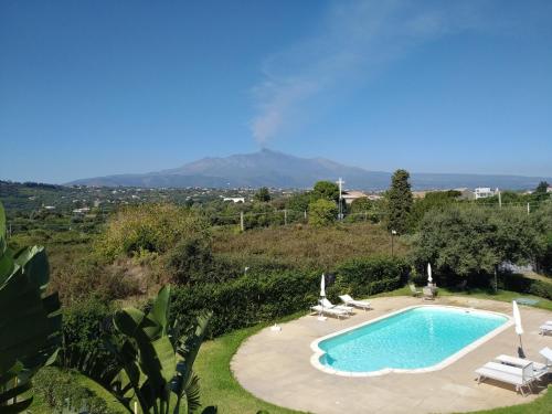 una piscina con 2 tumbonas y una montaña en Case Vacanze Residence Trinacria, en Acireale