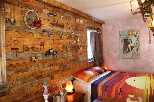 Un dormitorio con una pared de madera y una cama en A casa di Sandra, costa dei Trabocchi, en Paglieta