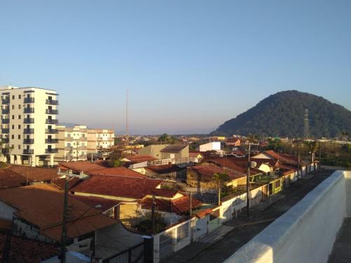 Blick auf eine Stadt mit Gebäuden und einem Berg in der Unterkunft Pé na areia in Mongaguá