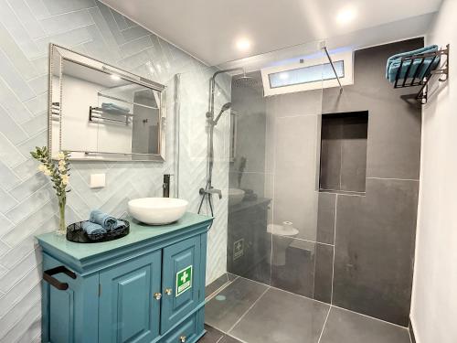 La salle de bains est pourvue d'une armoire bleue, d'un lavabo et d'une douche. dans l'établissement Casa da Horta by Atlantic Holiday, à Santa Cruz
