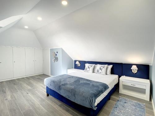 een slaapkamer met een blauw en wit bed en witte kasten bij Casa da Horta by Atlantic Holiday in Santa Cruz