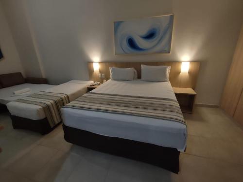 a hotel room with two beds in a room at Hot Springs Flat Apart-Hotel Master Luxo com Banheira in Caldas Novas