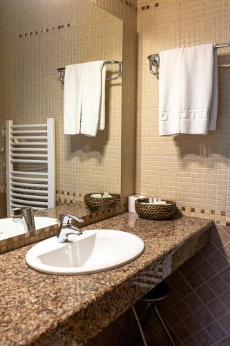 a bathroom with a sink and a mirror and towels at Euro Garni Hotel in Belgrade