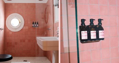 a bathroom with a sink and some bottles on the wall at Il Capri Hotel in Capri