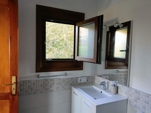 a bathroom with a sink and two windows at Casa de campo 2 Ortigal Tenerife in La Esperanza
