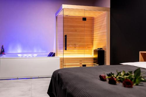 a bedroom with a tub and a bed with flowers on it at Warowna 2 Premium Spa Jacuzzi & Sauna in Pszczyna